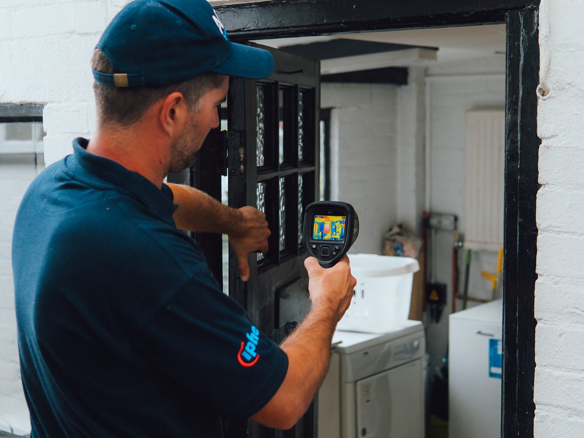 An ADI Leak Detection engineer scanning a utility room with a thermal imaging camera