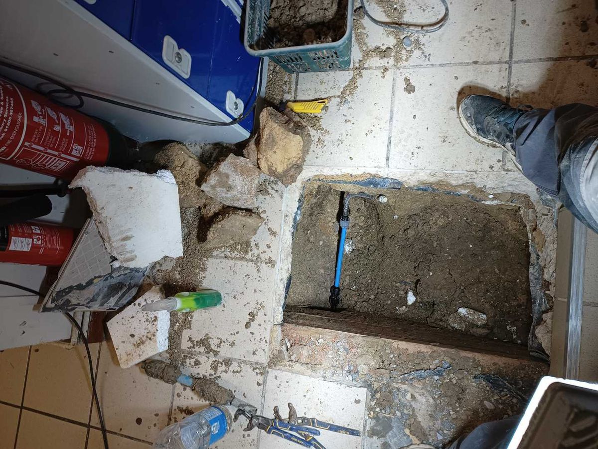 The shop floor opened up to expose the blue water supply pipe